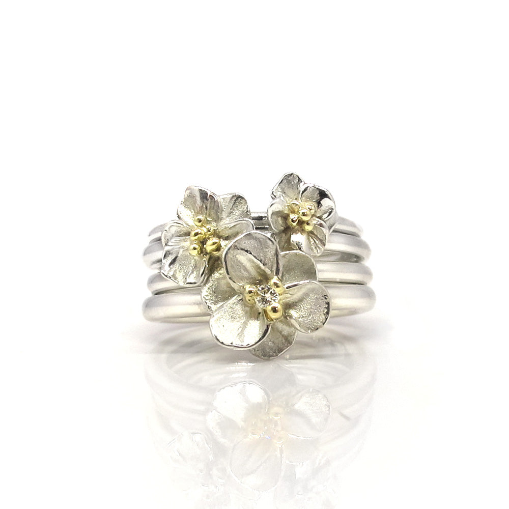 Silberner Blumenring mit goldenen Punkten.