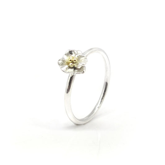 Silberner Blumenring mit goldenen Punkten.
