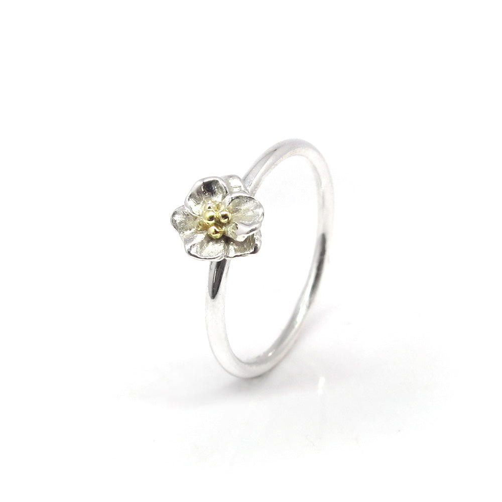 Silberner Blumenring mit goldenen Punkten.
